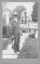 SA1425 - Full length portrait of a man holding various woodworking tools. Identified on the back. Includes ads for other views in the series. Photo is associated with the North Family., Winterthur Shaker Photograph and Post Card Collection 1851 to 1921c
